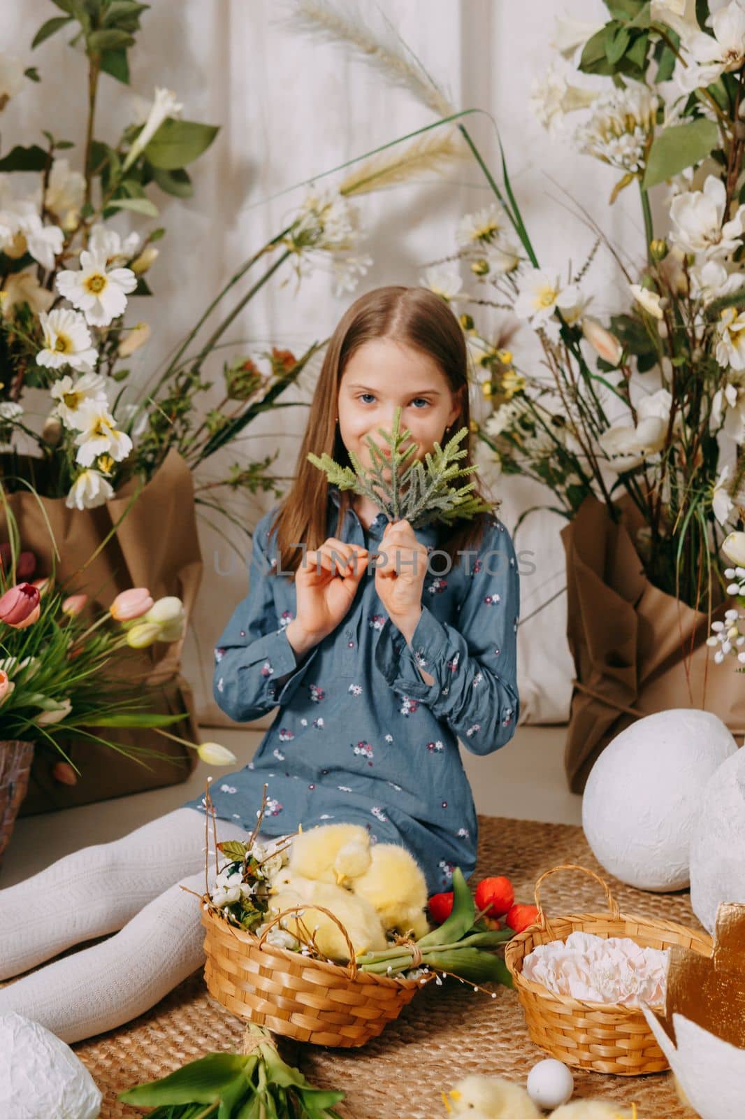 Two girls in a beautiful Easter photo zone with flowers, eggs, chickens and Easter bunnies. Happy Easter holiday