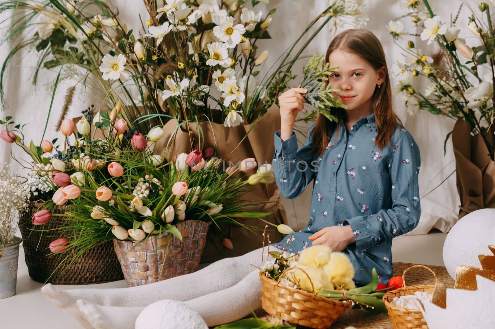 Two girls in a beautiful Easter photo zone with flowers, eggs, chickens and Easter bunnies. Happy Easter holiday