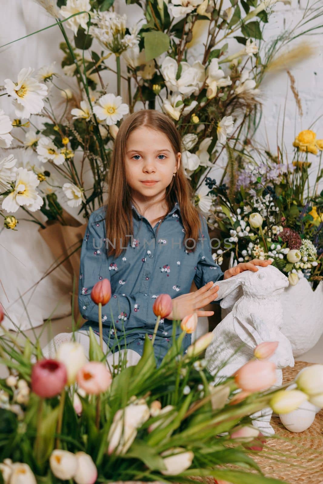 Two girls in a beautiful Easter photo zone with flowers, eggs, chickens and Easter bunnies. Happy Easter holiday. by Annu1tochka