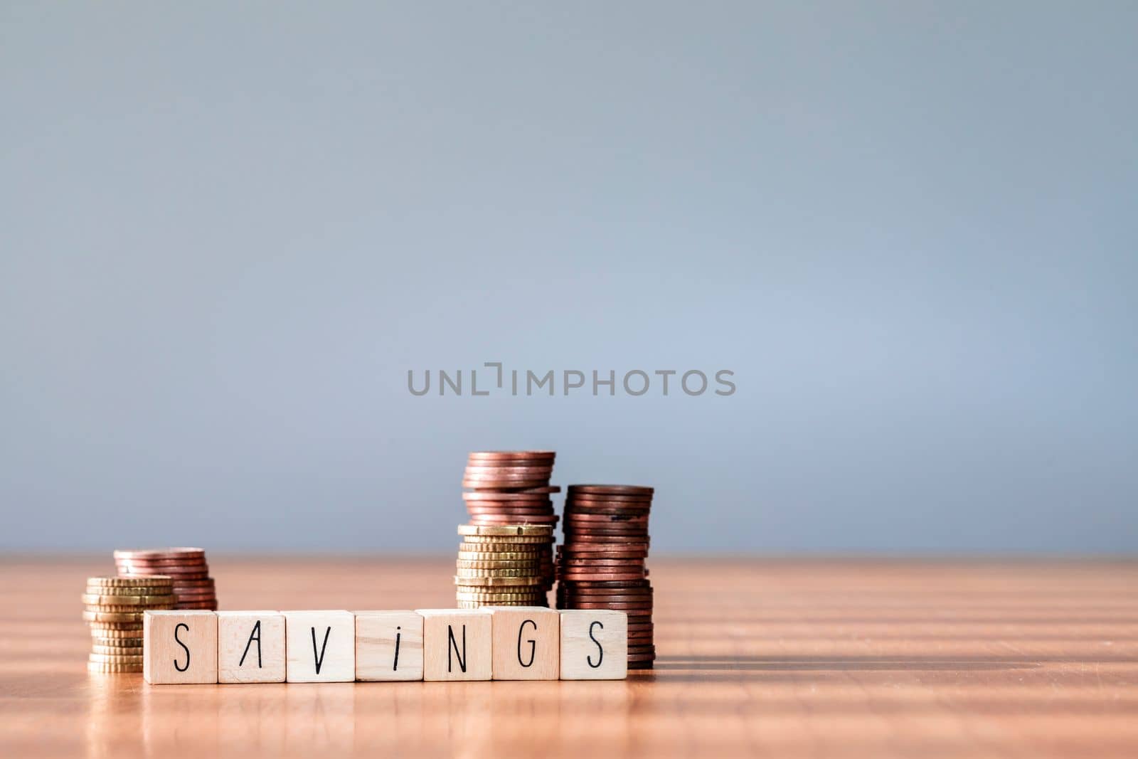 Stacking coins pile wooden box with text word savings for planning step up to growing, Saving money for retirement fund and the future plan concept. copy space succes