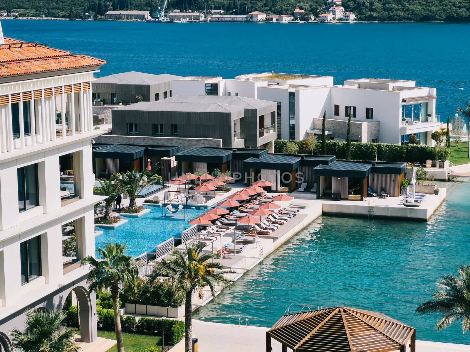 Swimming pool with private beach and sun loungers near the hotel on the seafront. High quality photo