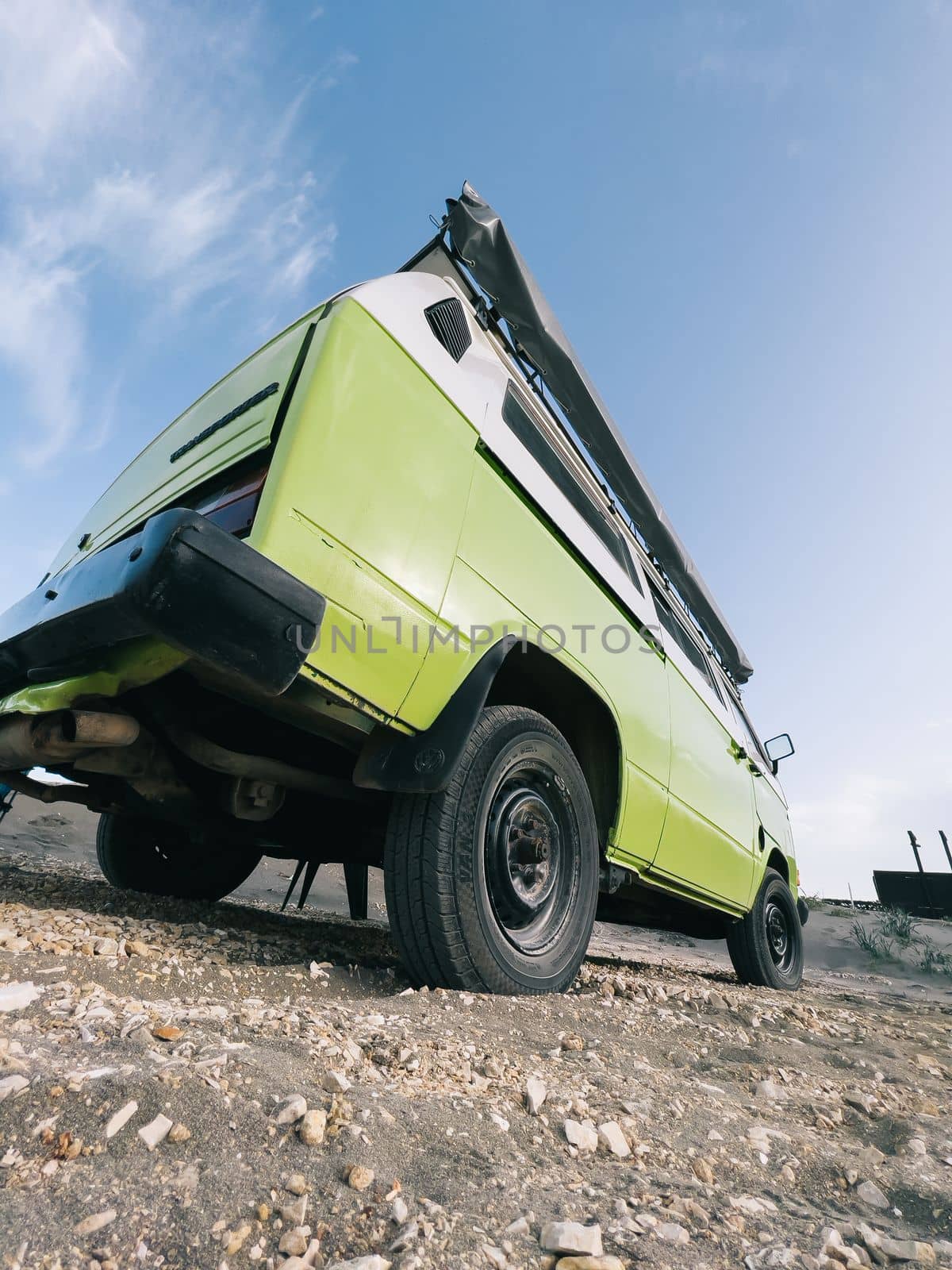 Green van stands on a rocky beach. Bottom view. High quality photo