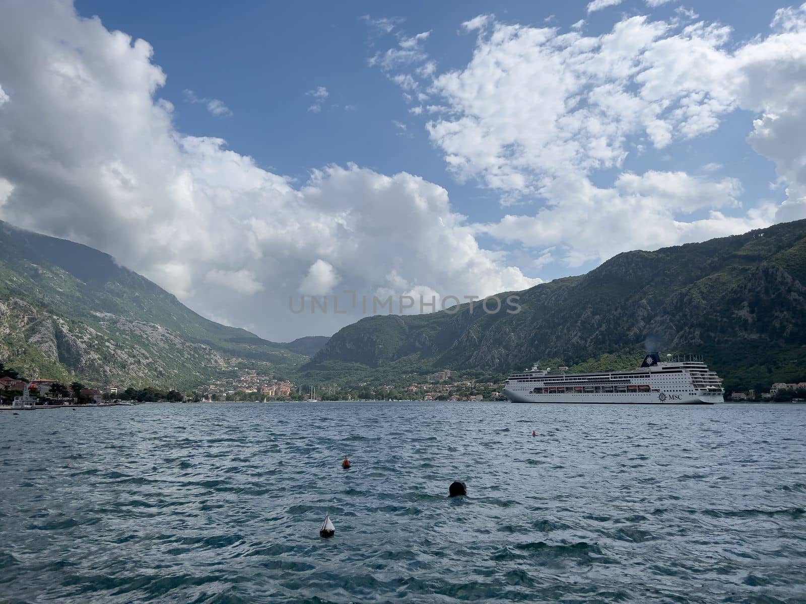 Huge passenger liner floats on the sea against the backdrop of mountains. High quality photo