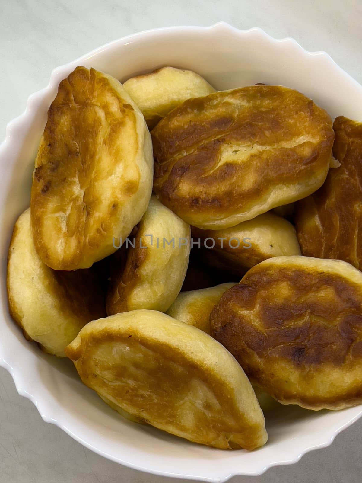 Fried pancakes lie in a deep bowl on the table. High quality photo