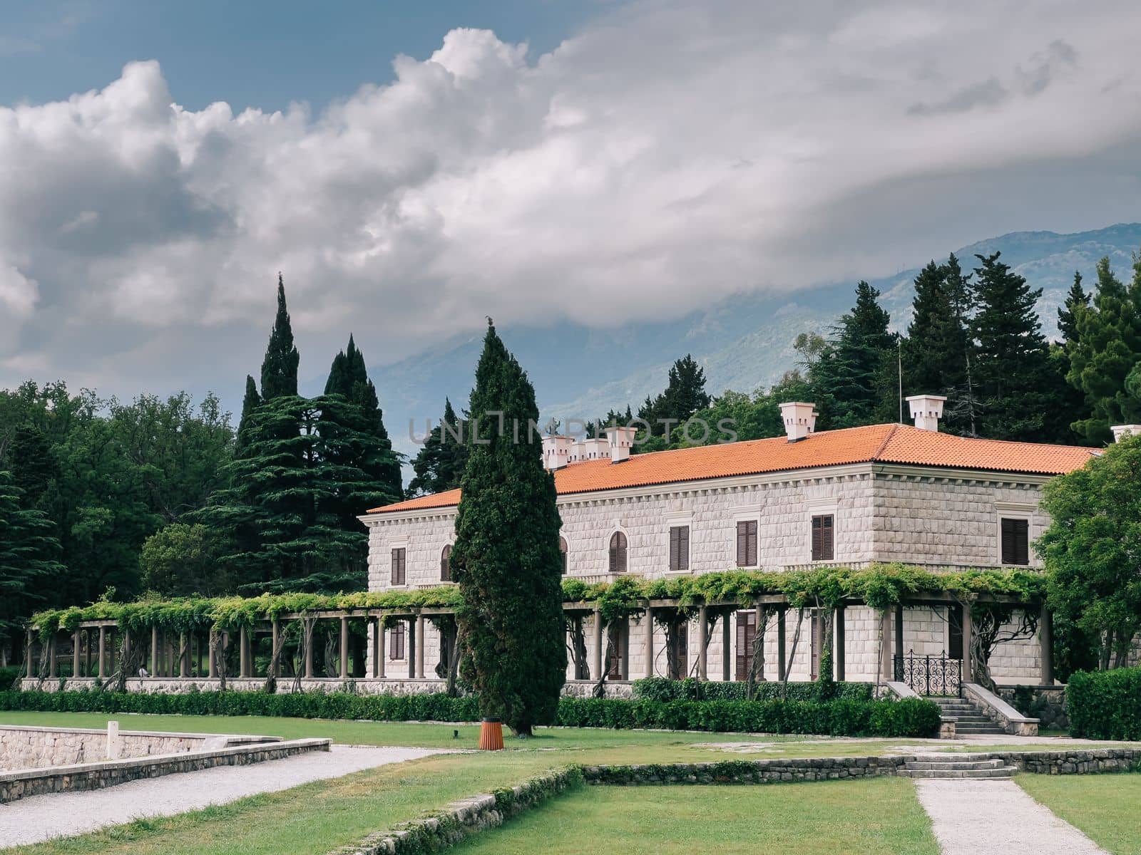 Villa Milocer with a pergola covered with green ivy and a luxurious garden. High quality photo