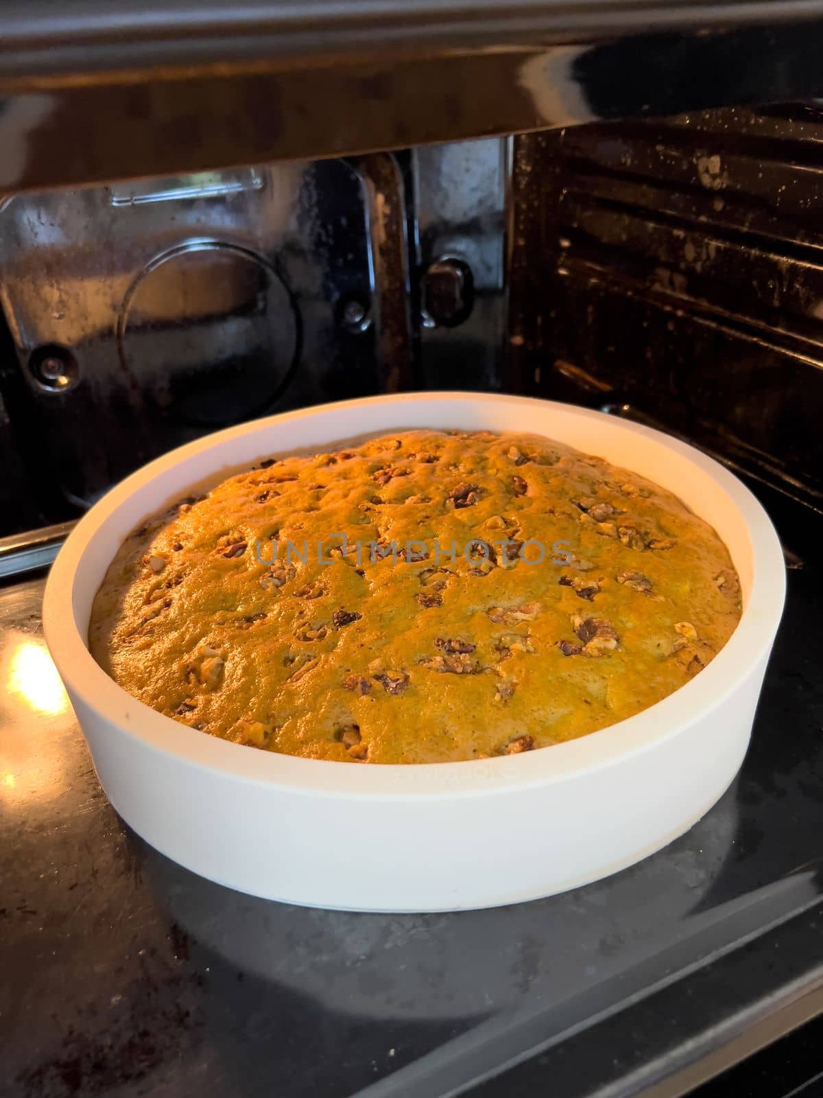 Pie with nuts is baked in a white form in the oven. High quality photo