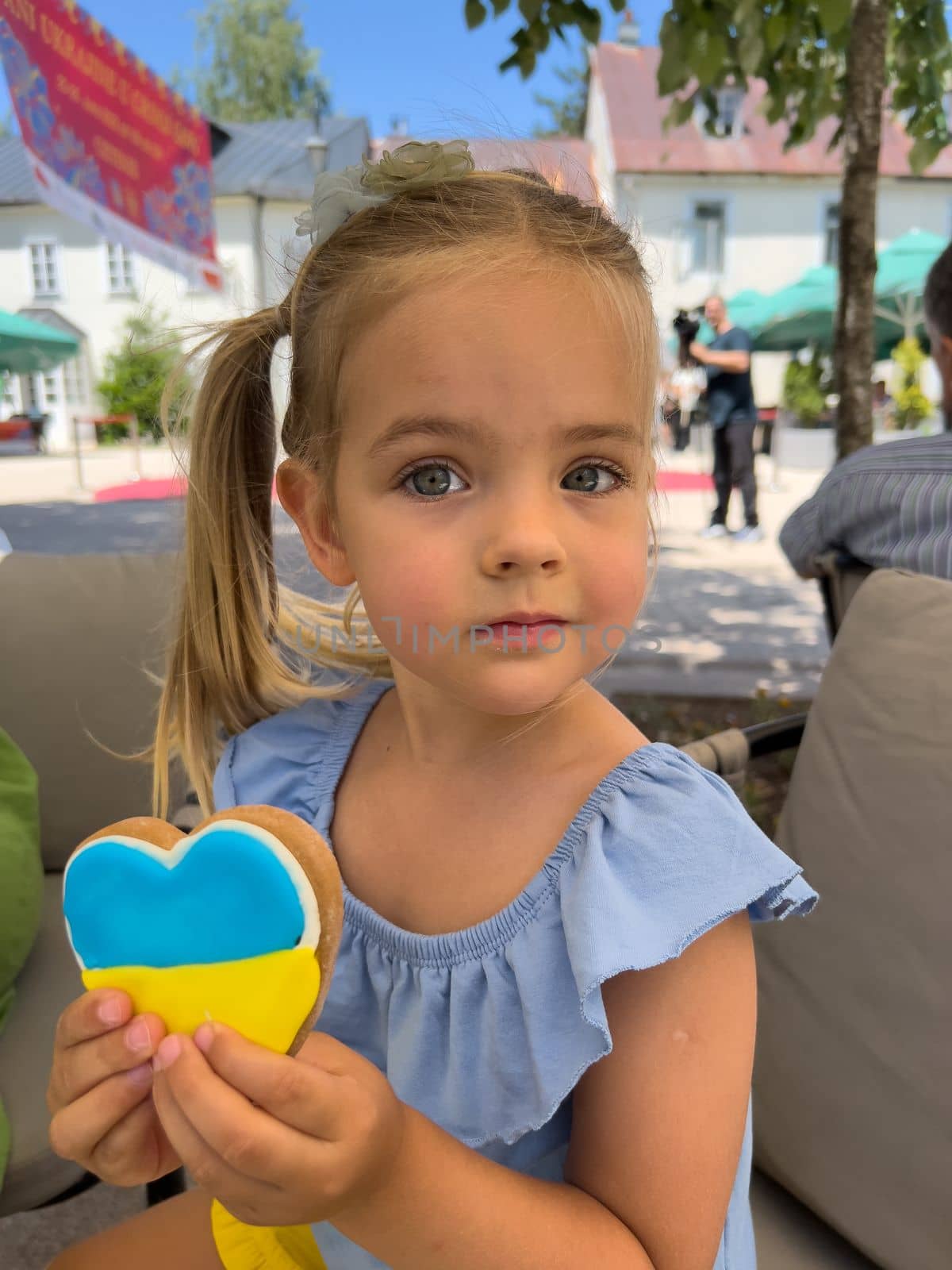 Little girl holding blue and yellow heart shaped cookies. High quality photo