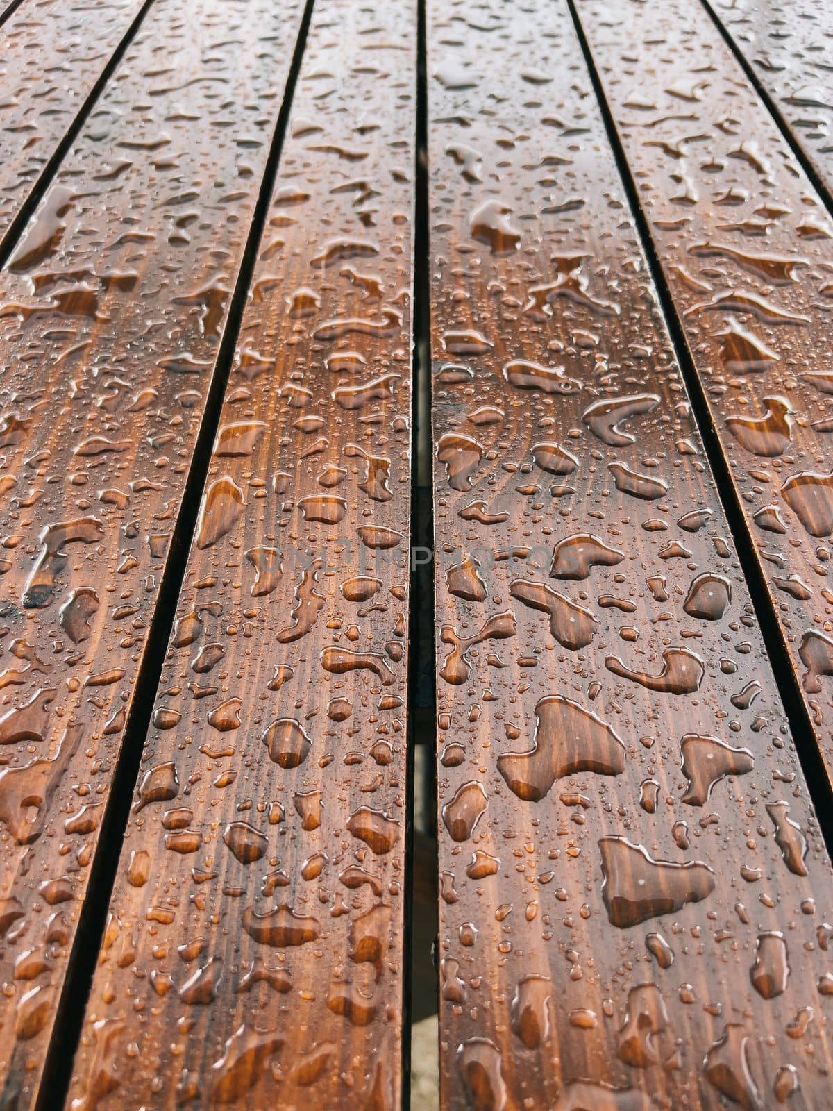 Raindrops on a brown wooden surface. Close-up. High quality photo