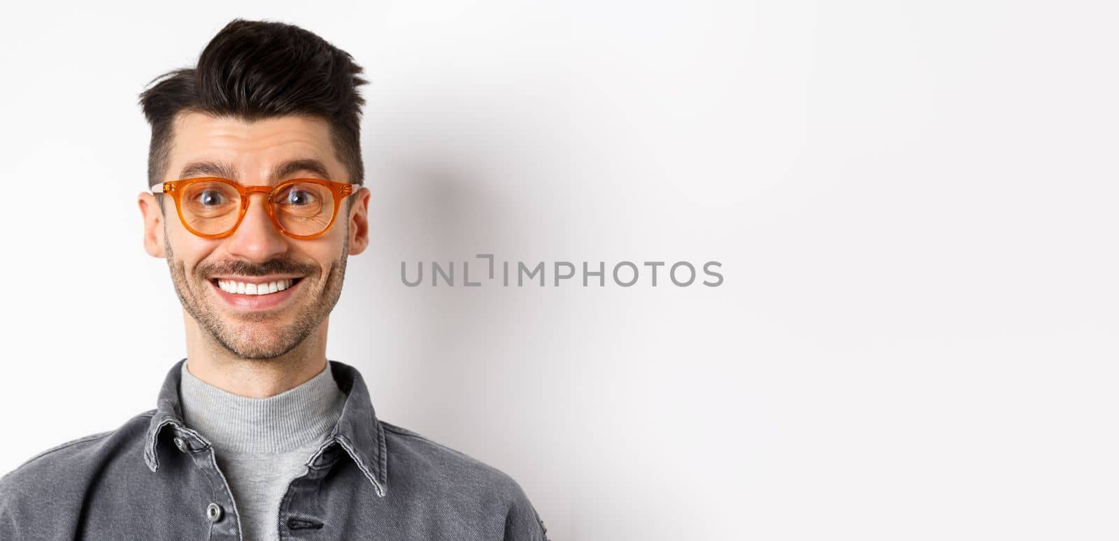 Close up portrait of happy man face, wearing stylish glasses and smiling, standing on white background.