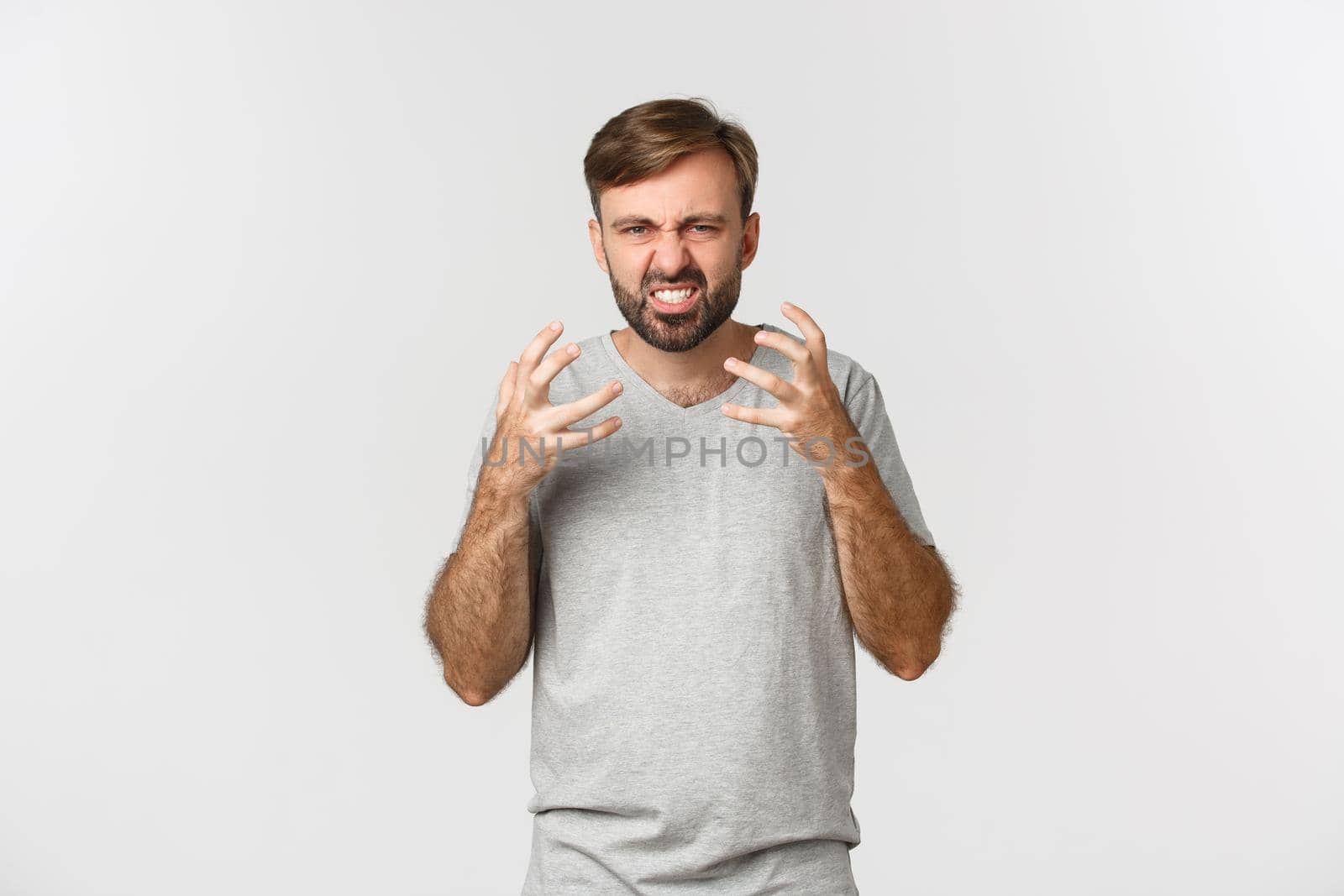 Portrait of angry bearded man, shouting and shaking hands frustrated, standing mad over white background.