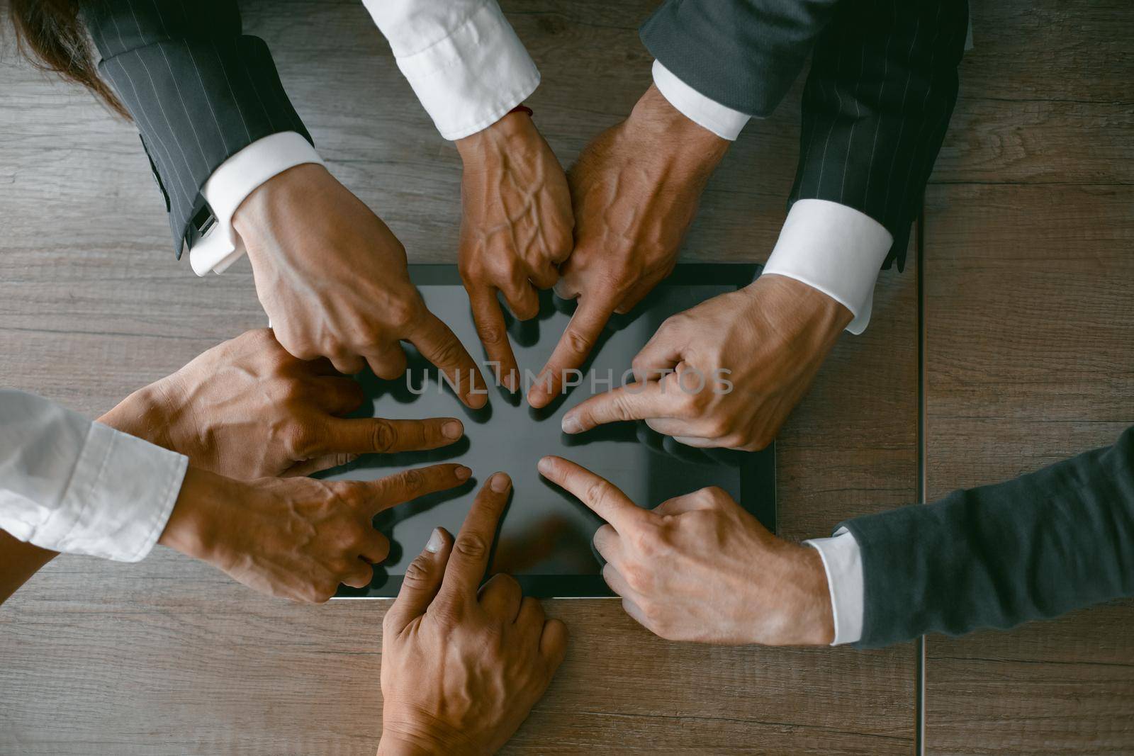Hands of business people touching screen of digital tablet. Toned image. Close up shot. High angle view. High quality photo.