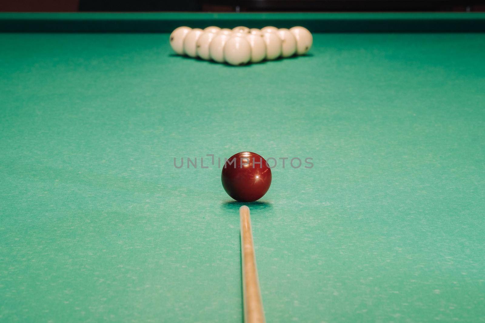 Start of the game of billiards on the green table.The balls are arranged in a triangle on the table.