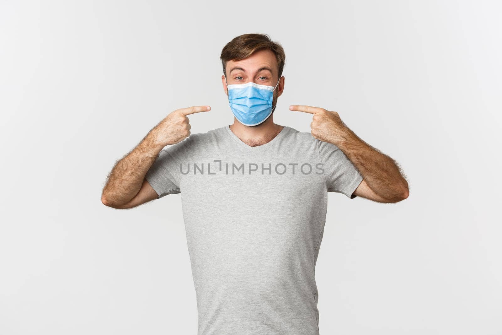 Concept of pandemic, coronavirus and social-distancing. Image of handsome man in gray t-shirt, recommending to wear medical masks during covid-19, white background by Benzoix