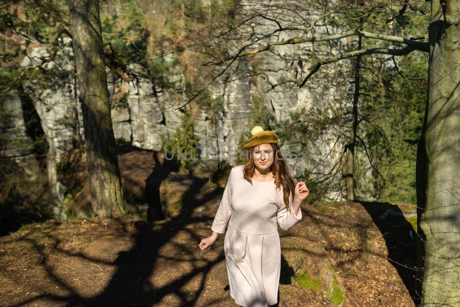 a girl in a pink dress and hat on the background of mountains and gorges in Swiss Saxony, Germany, Bastei.