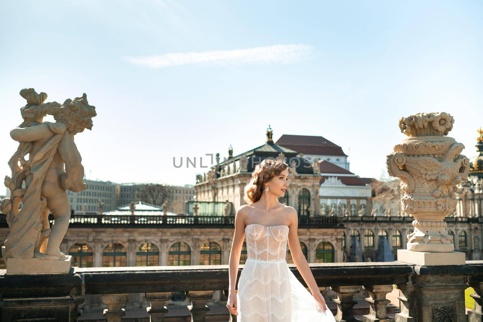 A bride in a white dress on a wedding walk at the famous Baroque Zwinger Palace in Dresden, Saxony, Germany by Lobachad