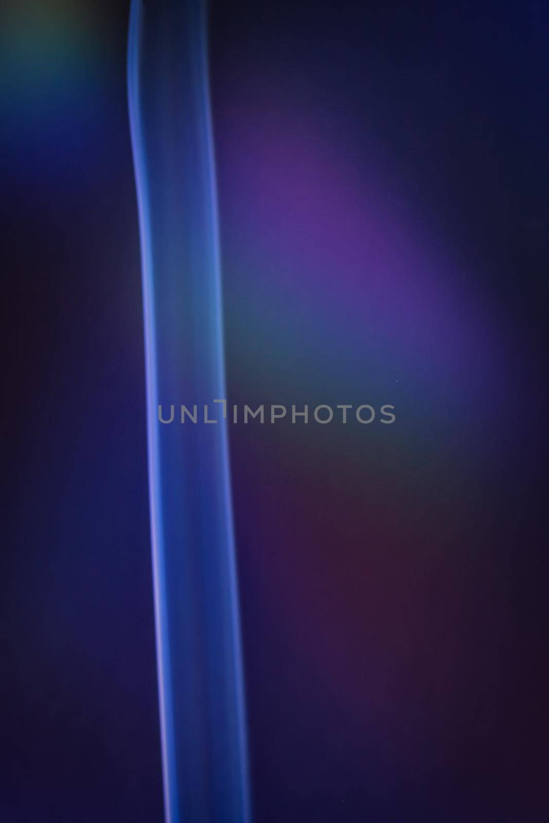 A vertical shot of smoke in colorfull backlight with a blue note