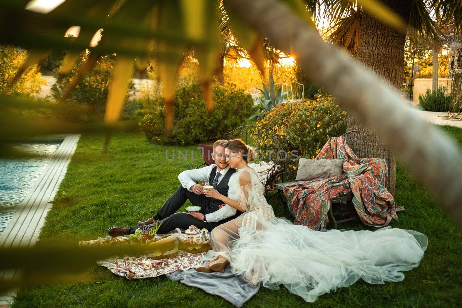 Newlyweds ' dinner on the lawn at sunset.A couple sits and drinks tea at sunset in France.