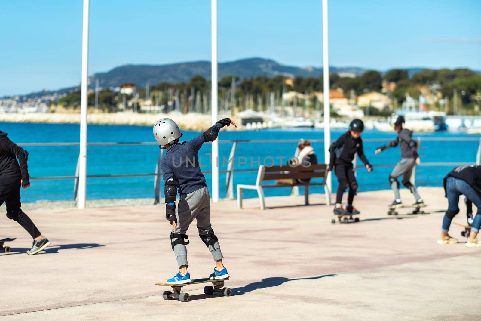 Children on skateboards on the embankment of the village of Saint-Cyr-sur-mer, France.