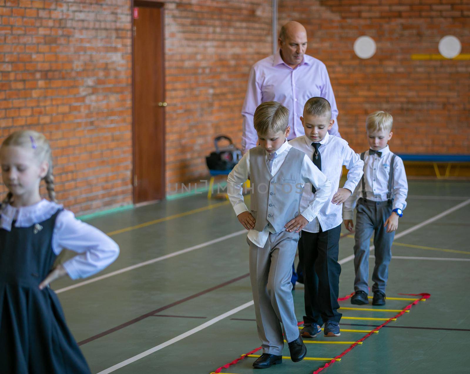 First graders in their first physical education class at the gym. Moscow, Russia, September 2, 2019 by Yurich32