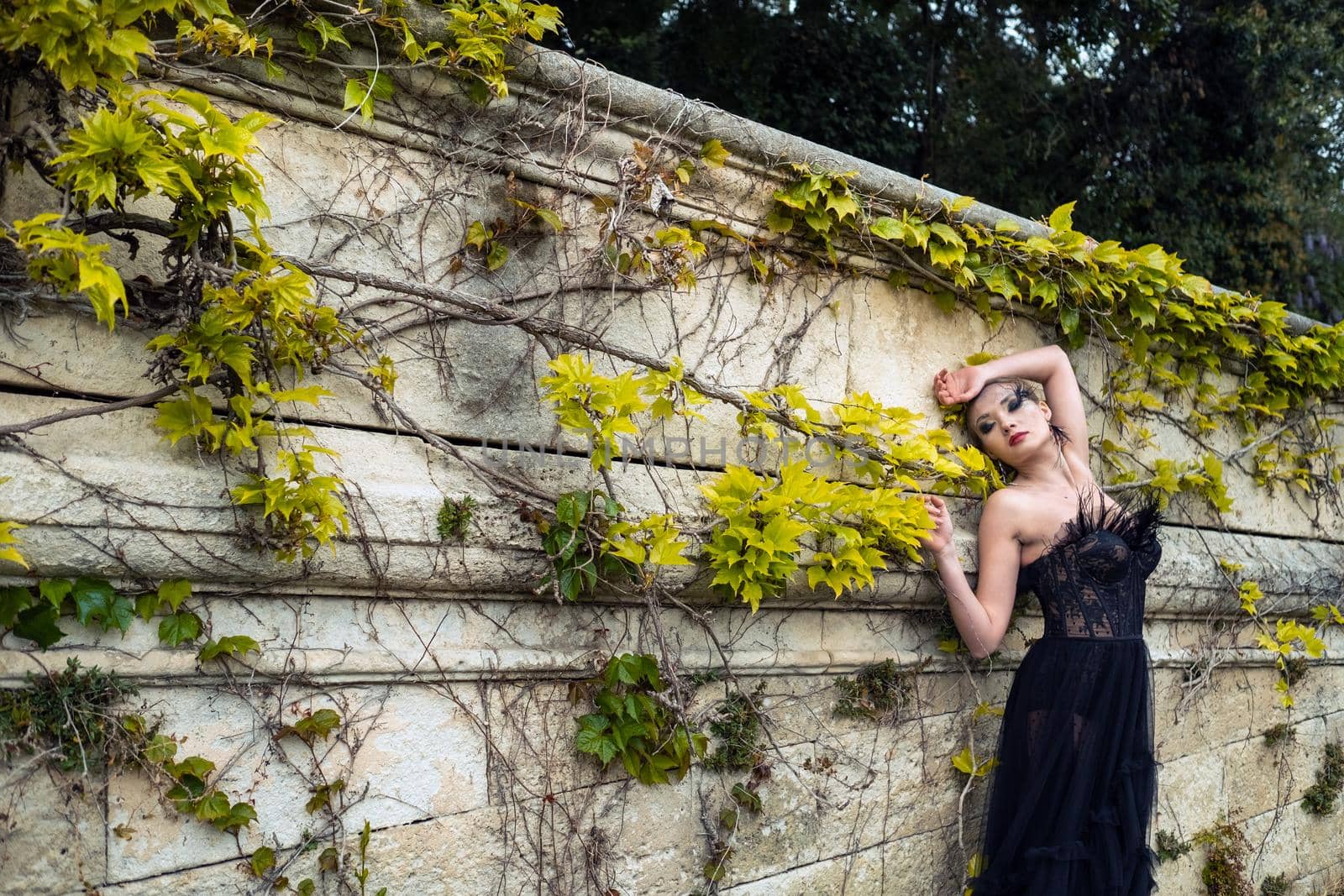 A stylish bride in a black wedding dress in the ancient French city of Avignon. A model in a black dress.