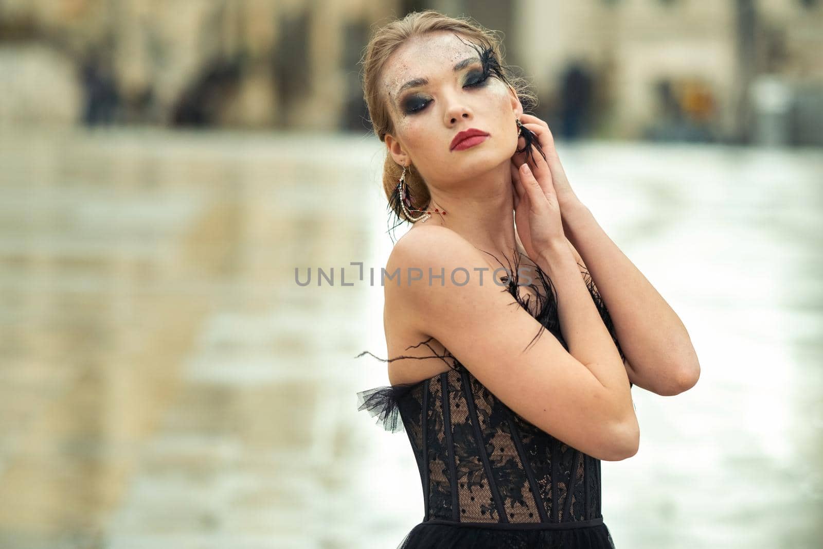 A stylish bride in a black wedding dress in the ancient French city of Avignon. A model in a black dress.