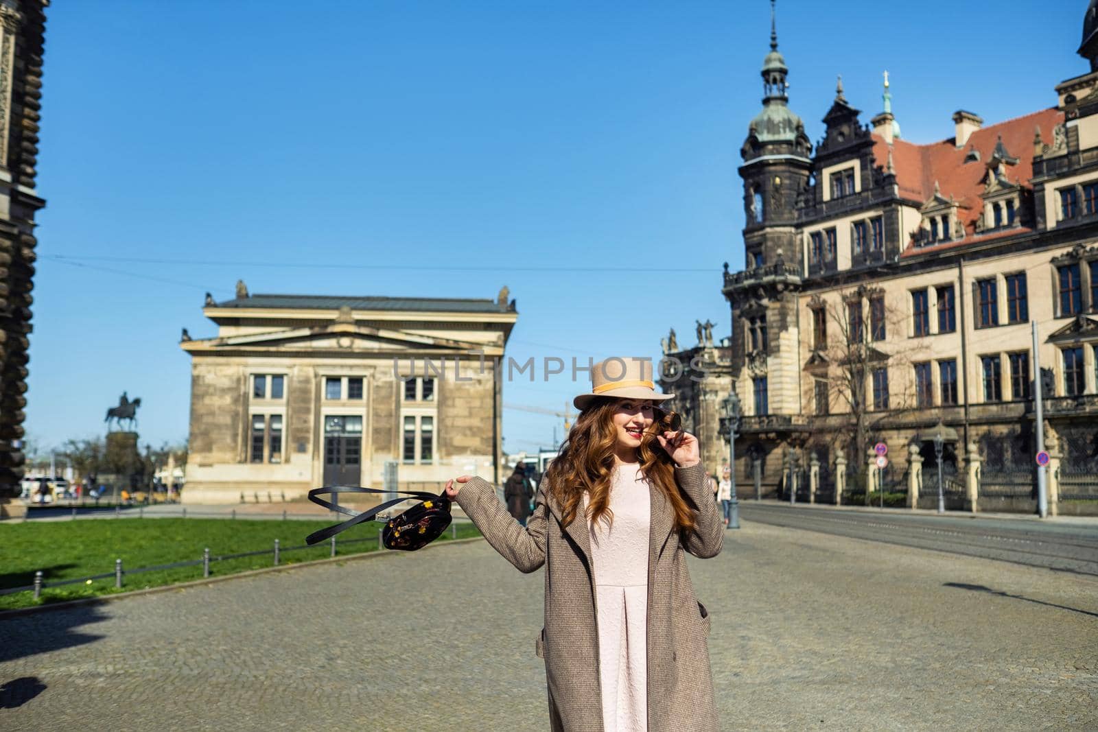 a girl in a coat and hat on a street in the city of Dresden. Saxon Switzerland, Germany by Lobachad