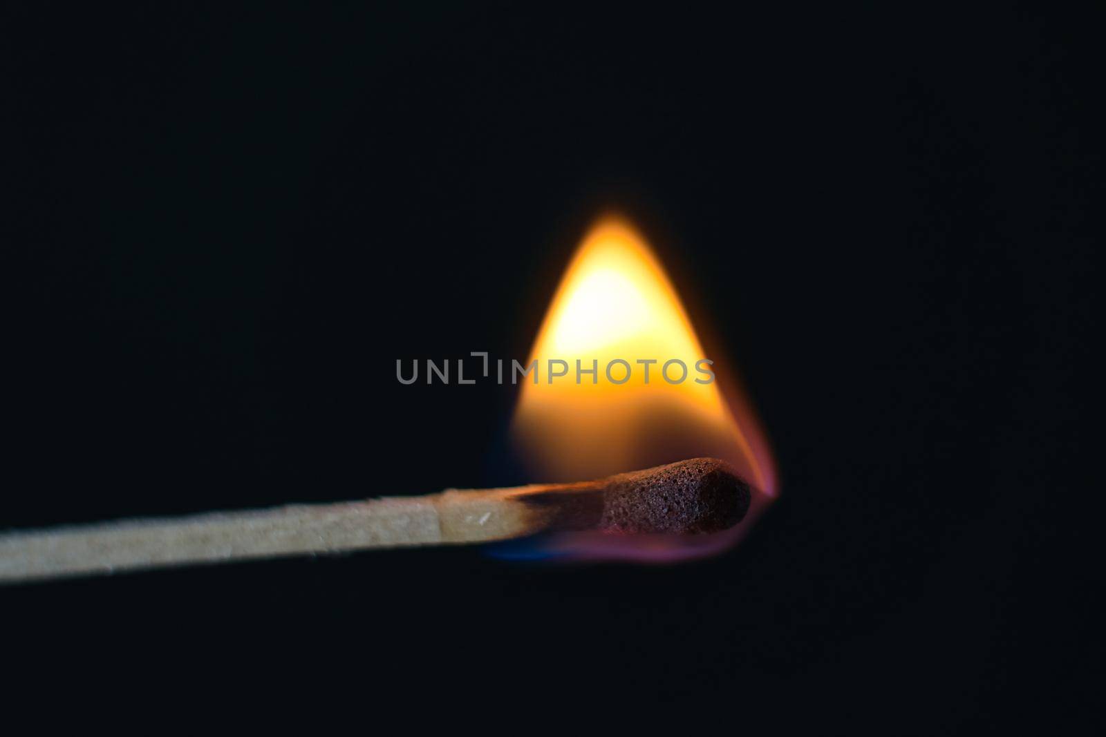 A selective focus of a match on fire on black background