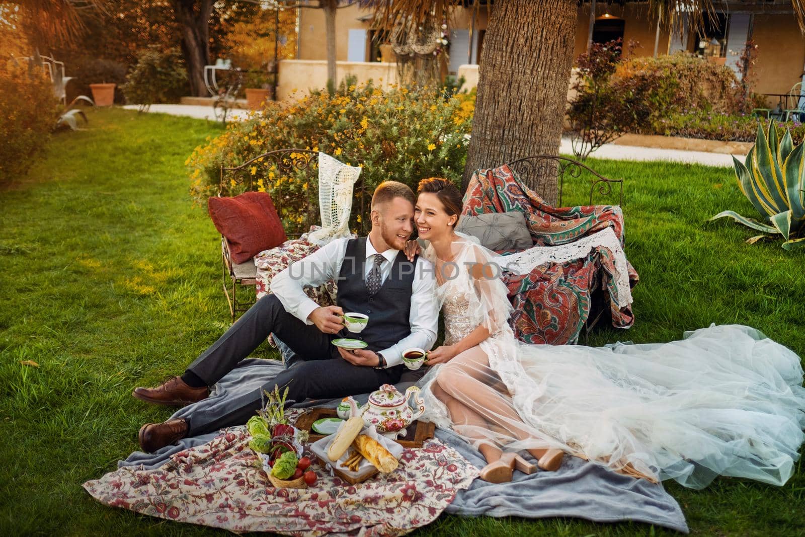 Newlyweds ' dinner on the lawn at sunset.A couple sits and drinks tea at sunset in France.