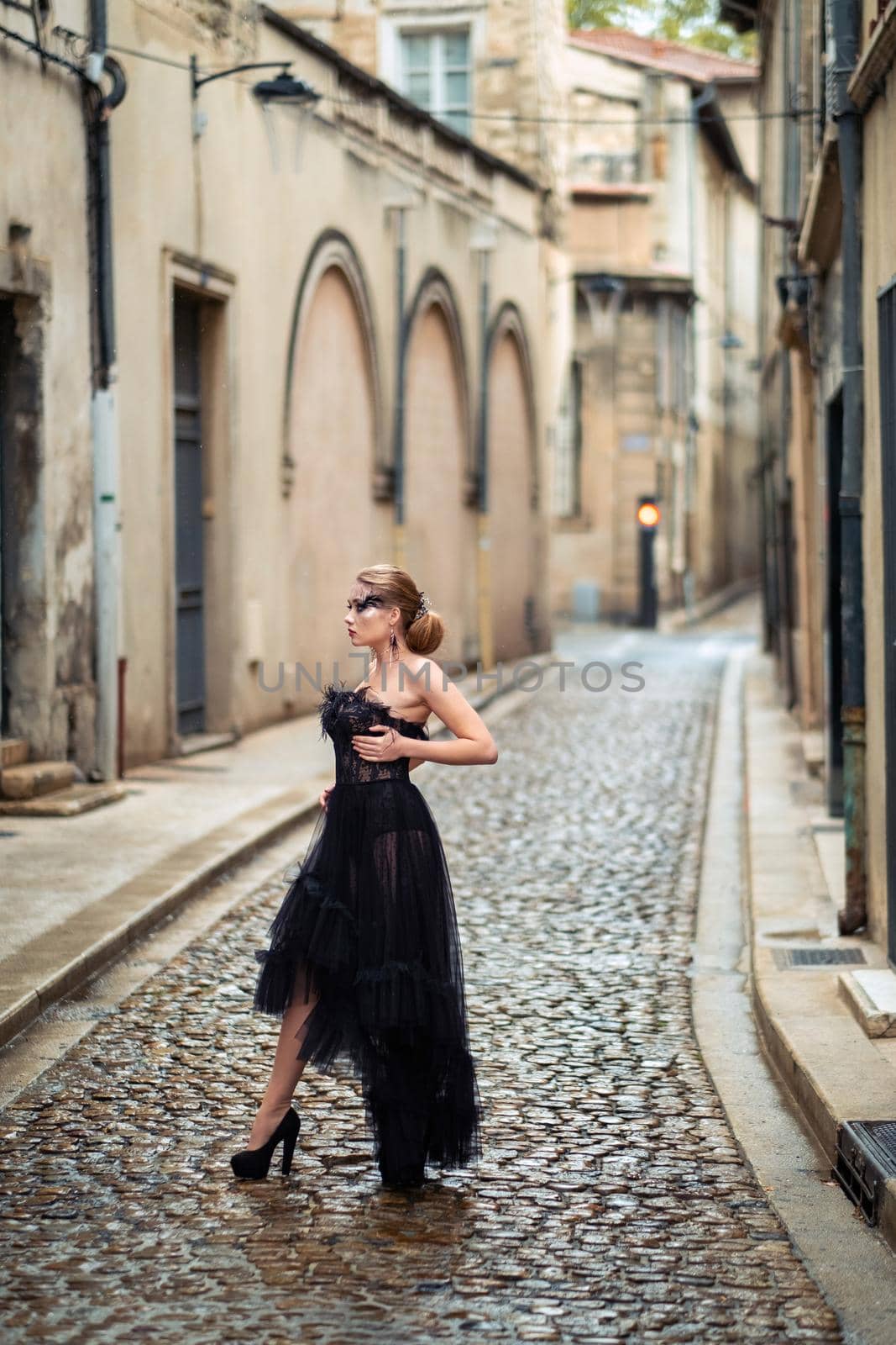 A stylish bride in a black wedding dress in the ancient French city of Avignon. A model in a black dress by Lobachad