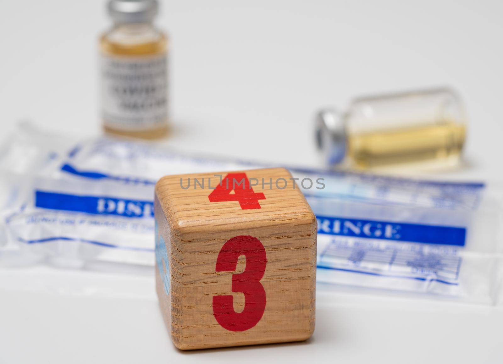 Booster shot for mRNA vaccines for Covid-19 with wooden block with number three with disposable syringes to enhance protection against virus