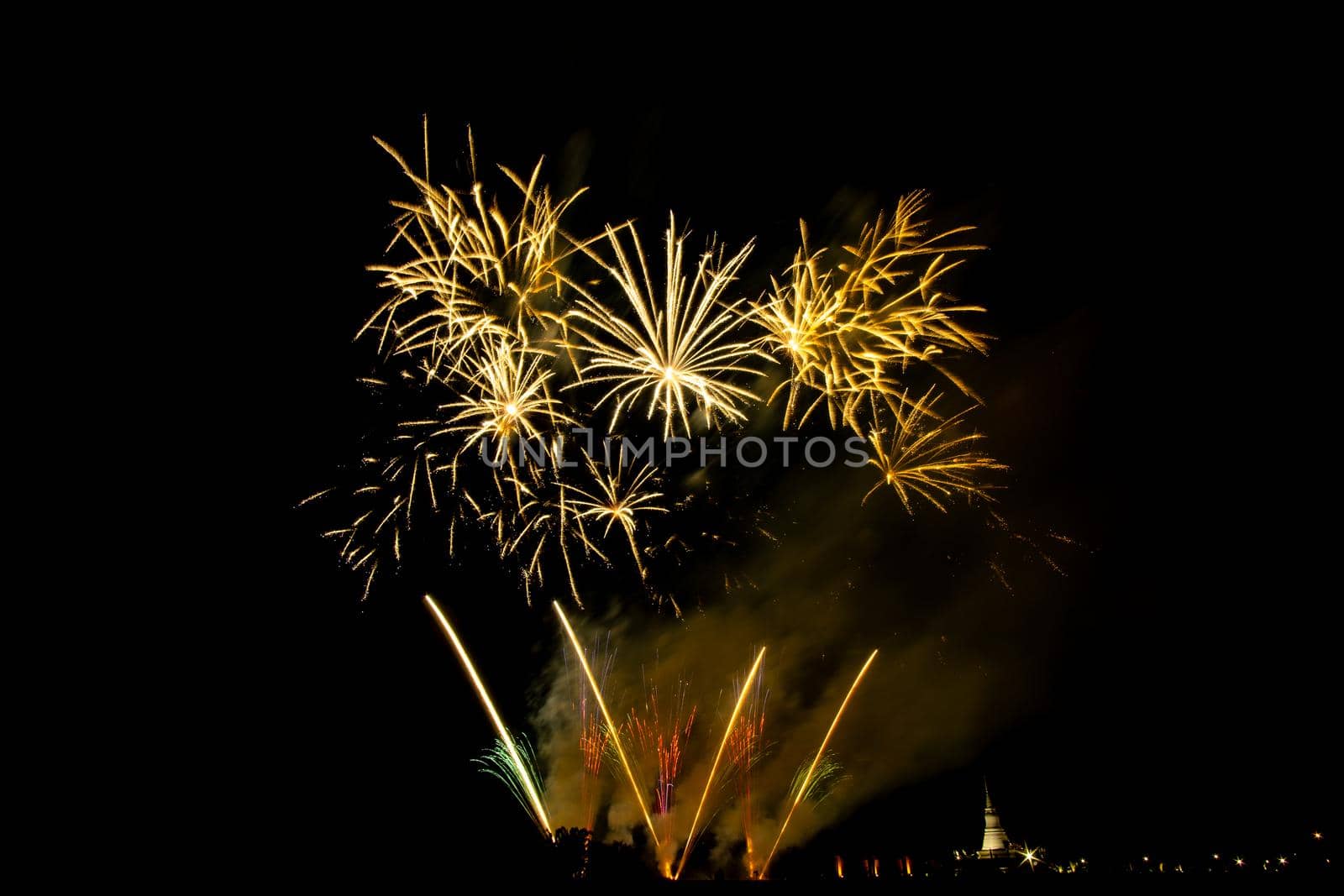 Huge, colorful fireworks over the rice fields at dusk.