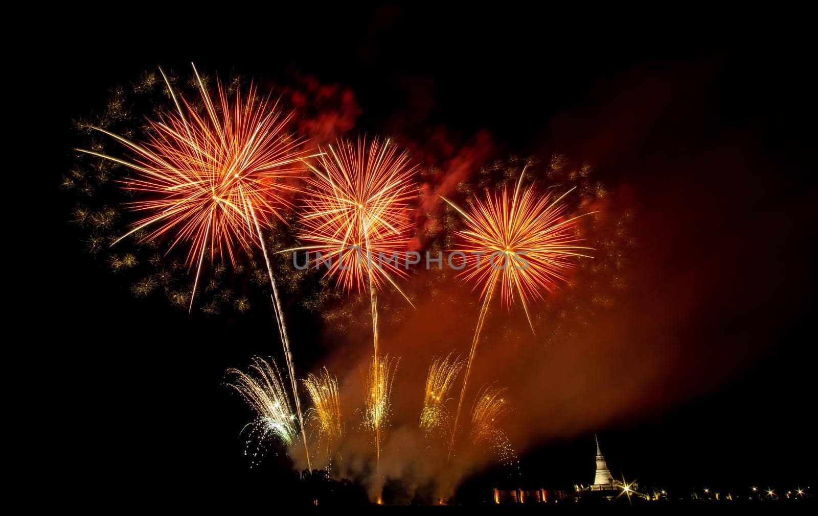 Huge, colorful fireworks over the rice fields at dusk.