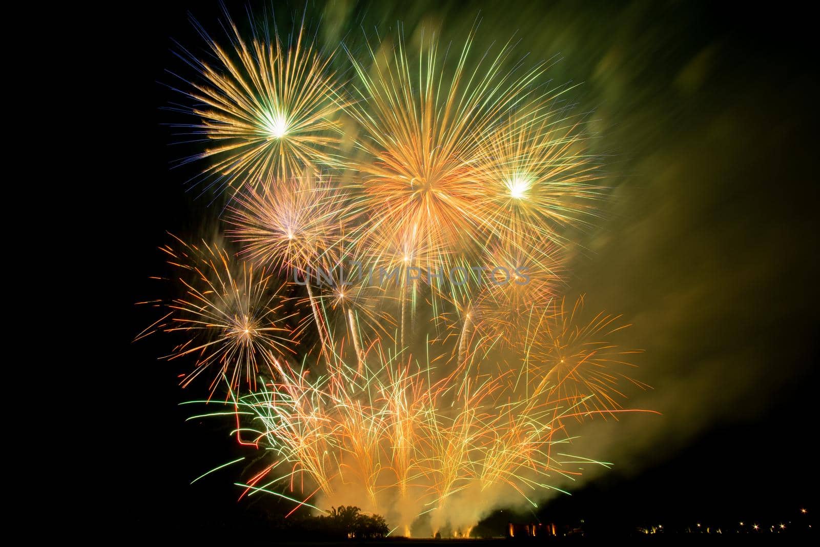 Huge, colorful fireworks over the rice fields at dusk.
