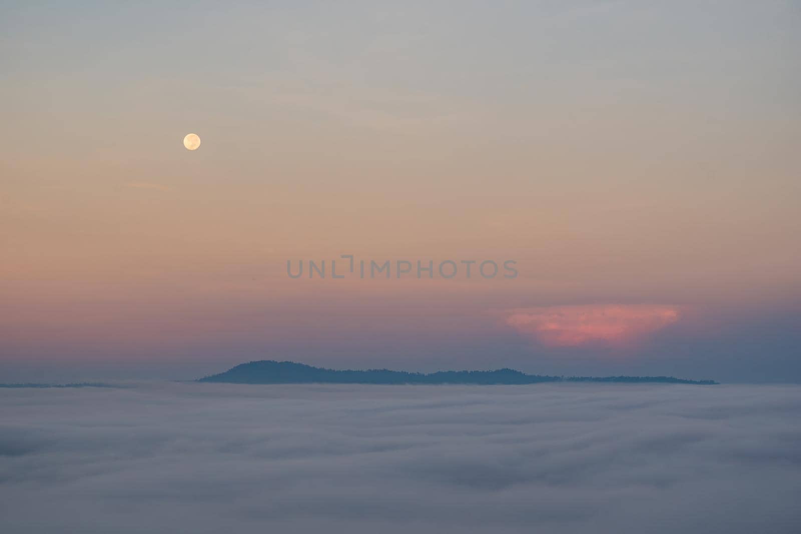 Full moon falling And the mist in the morning time. The color orange sky reflects the sun's rays.
