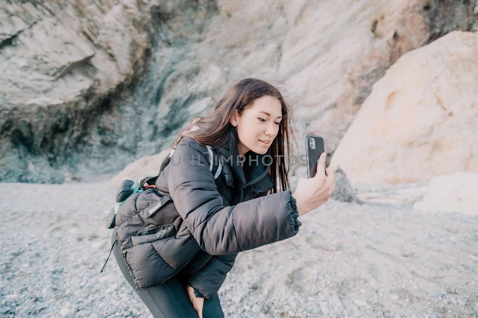 Portrait of cheerful female climber resting on a volcanic basalt by panophotograph