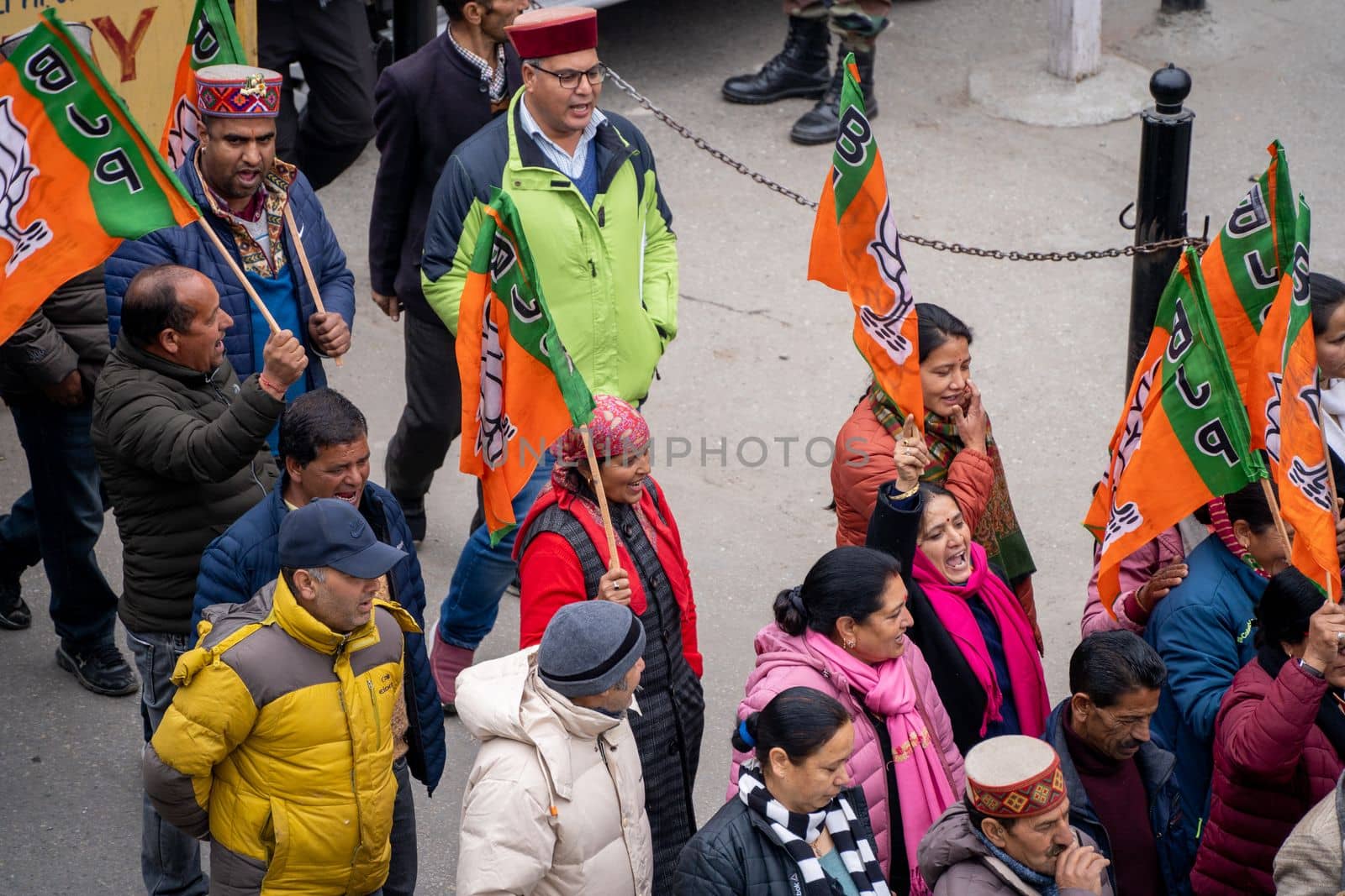 Delhi, India - circa 2022: aerial drone shot crowd people with saffron flags of BJP protesting or celebrating victory in hill station manali standing in circle with leader