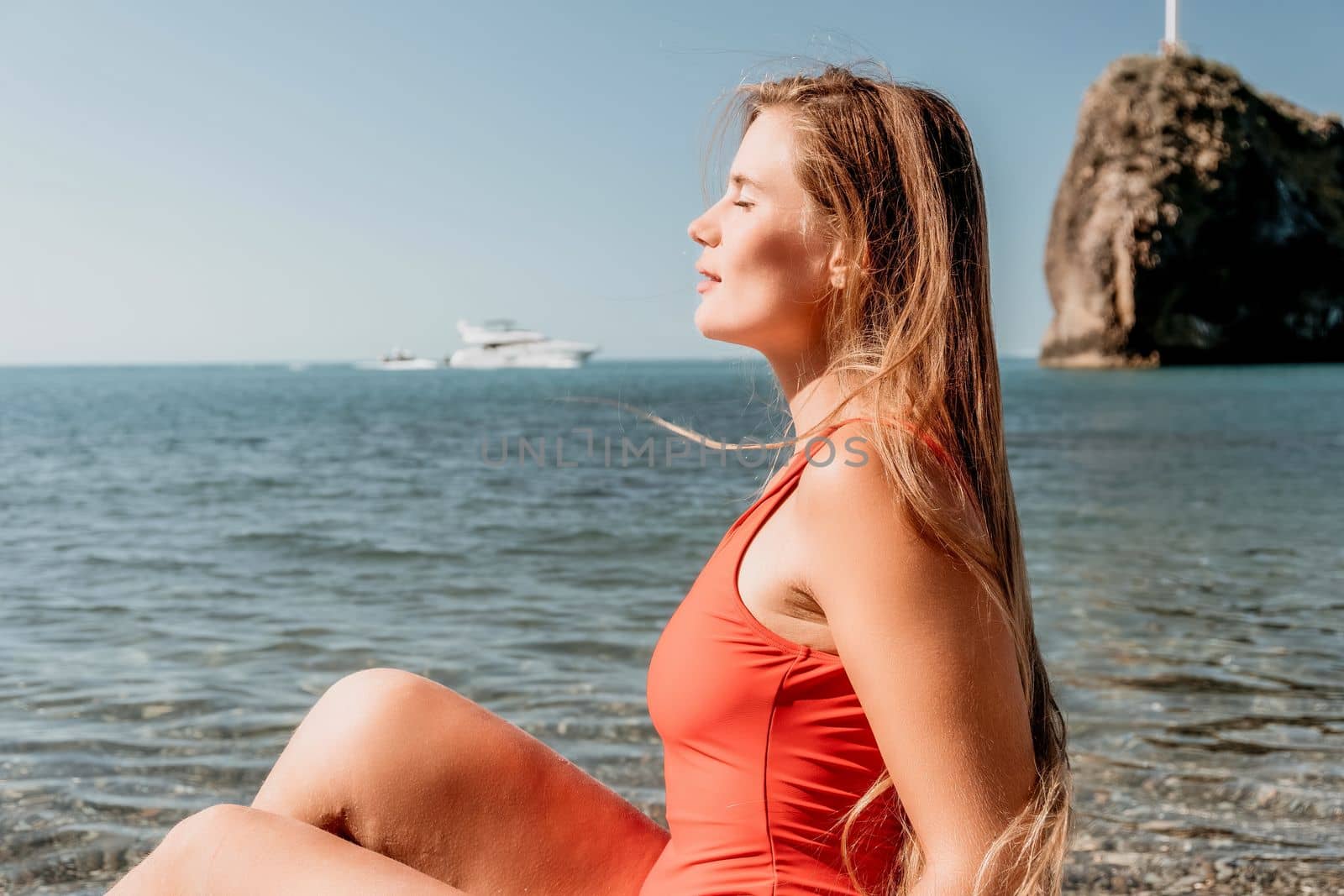 Sexy young woman in stylish bikini lying on seashore, closeup. Holiday, vacation and recreational concept.