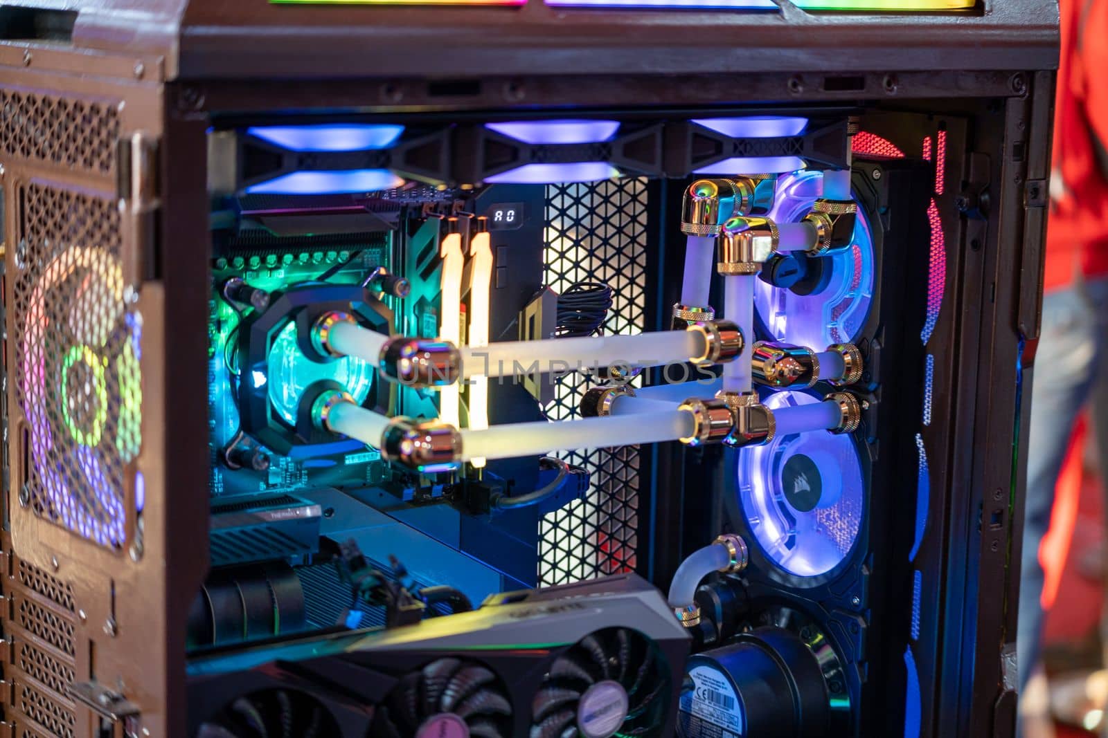 shot of overclocked CPU computer cabinet with water liquid cooled processors and RGB red green blue lighting with metal pipes running by Shalinimathur