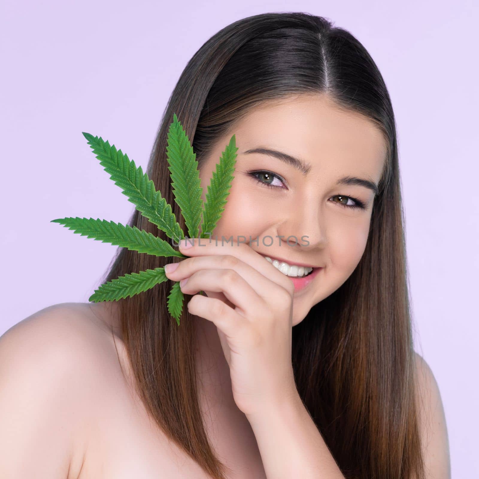 Closeup portrait of charming girl with fresh skin holding cannabis leaf. by biancoblue