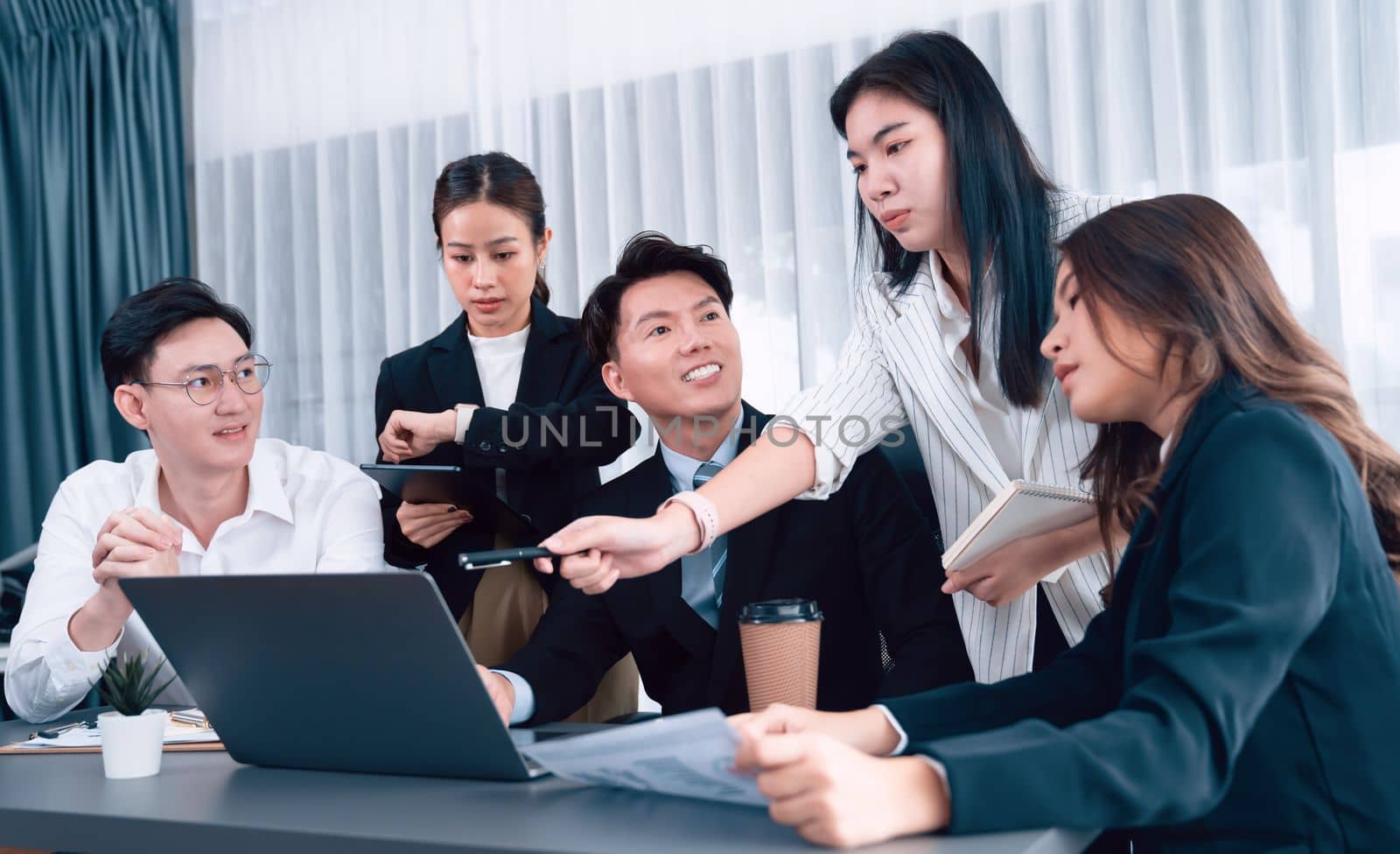 Harmony in office concept as business people analyzing dashboard paper together in workplace. Young colleagues give ideas at manager desk for discussion or strategy planning about project.