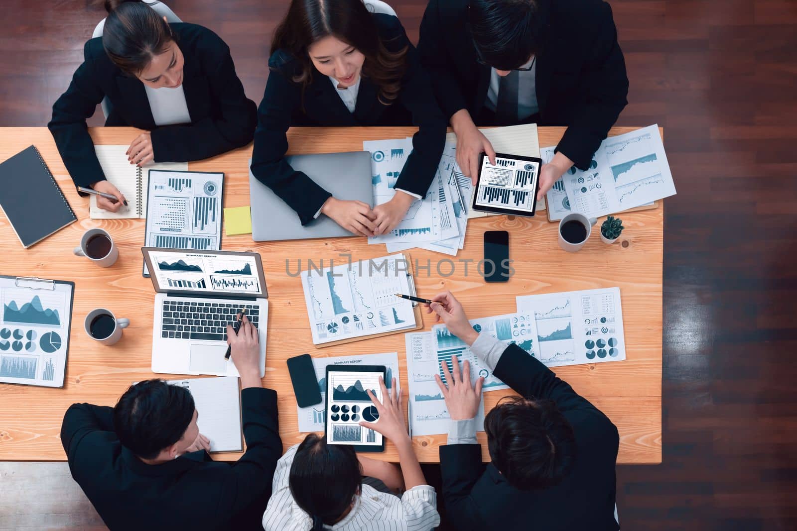 Top-view business team of financial data analysis meeting with business intelligence, report paper and dashboard on laptop for marketing strategy. Business people working together in office of harmony