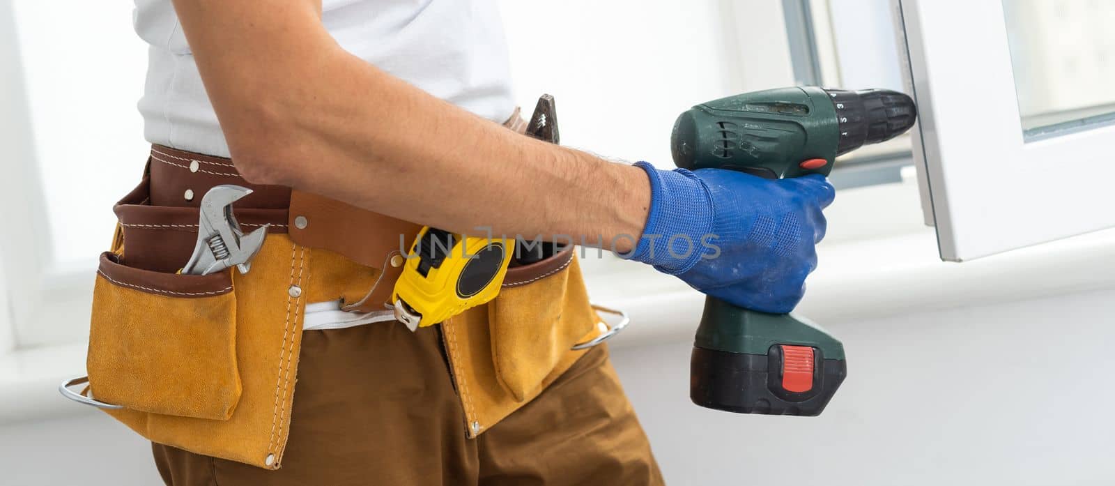 Close up of a mans hand holding screwdriver machine.