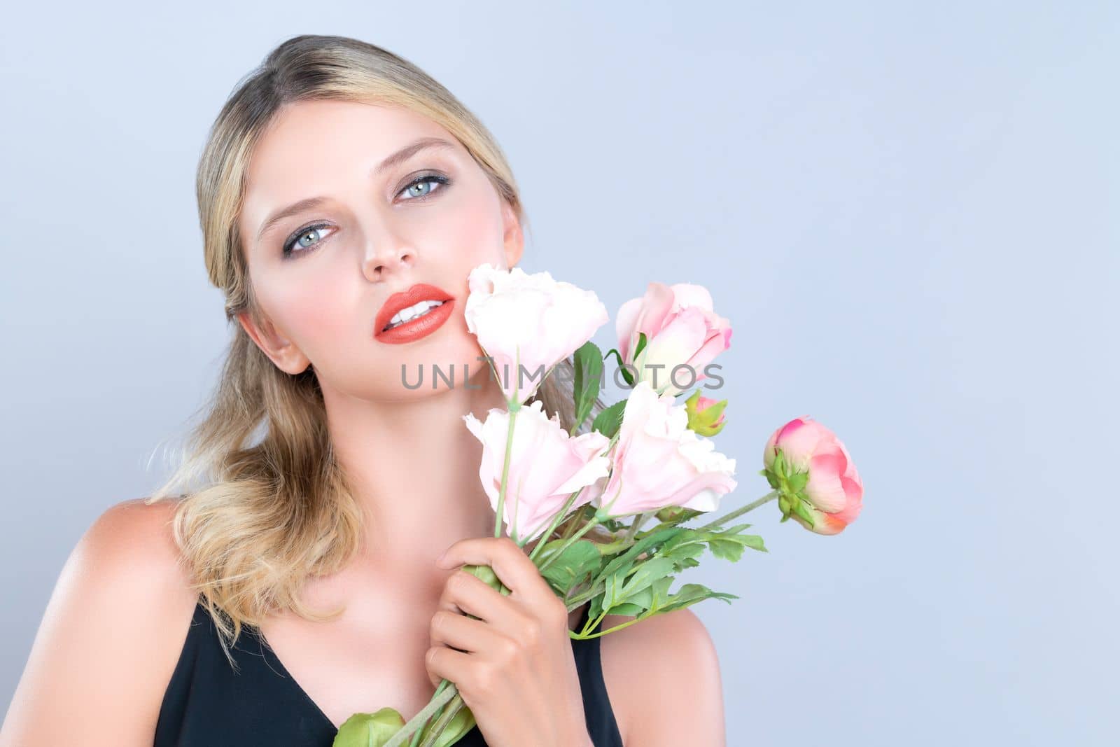 Closeup young woman with alluring flawless makeup and healthy soft skin holding rose for natural skincare treatment advertising in isolated background. Beautiful pretty model girl with flower concept.