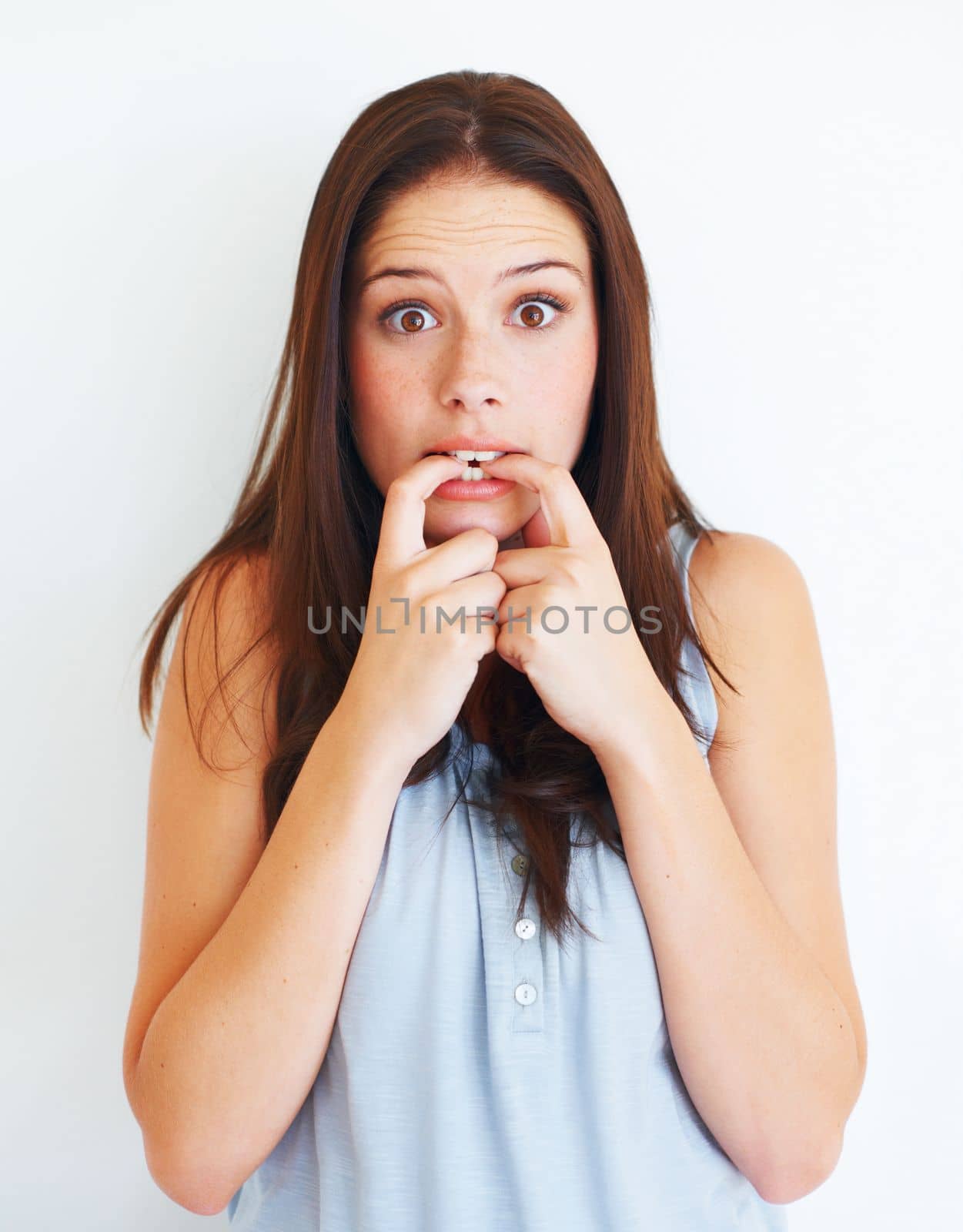 Someones in trouble. Nervous young woman looking at you while isolated on white
