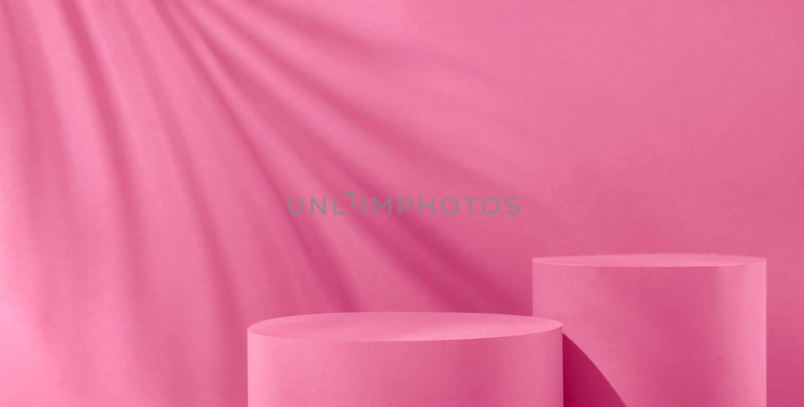 Magenta trend pastel color background with two geometric podiums to show the product and sunlight and shadow on the wall. by sergii_gnatiuk