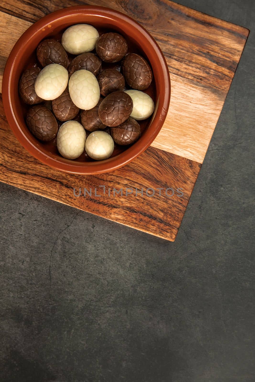 Chocolate easter eggs, candies on concrete background. Horizontal orientation, place for copyspace, flatlay, top view. Happy Easter concept dark design