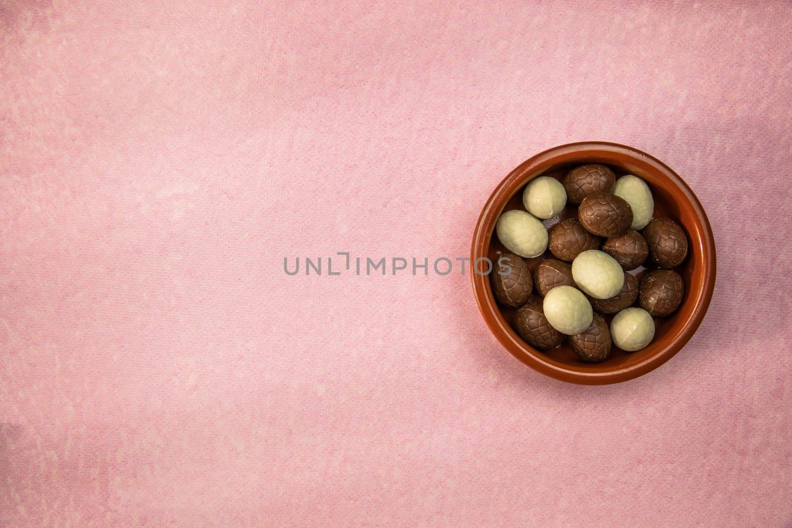 Easter. Composition with chocolate Easter eggs on pink background, space for text. top view Happy Easter holiday candy