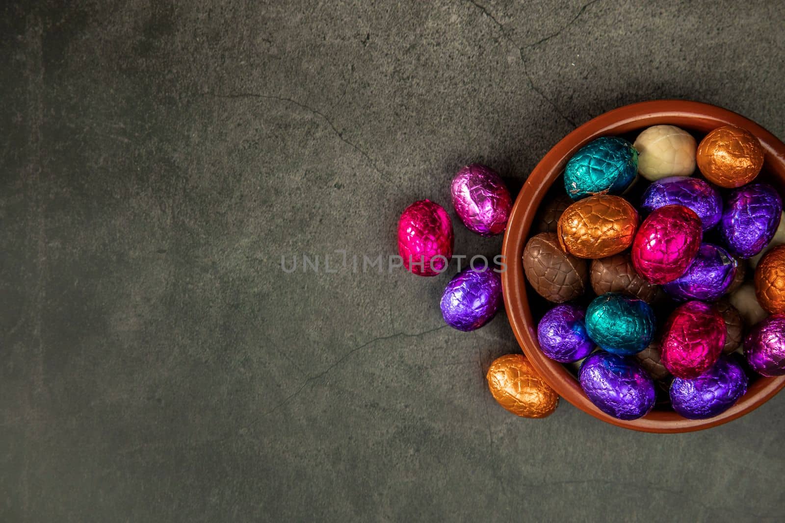 Sweet chocolate easter eggs and candies on grey table, flat lay with copy space, Happy Easter concept on concrete background texture candy concept