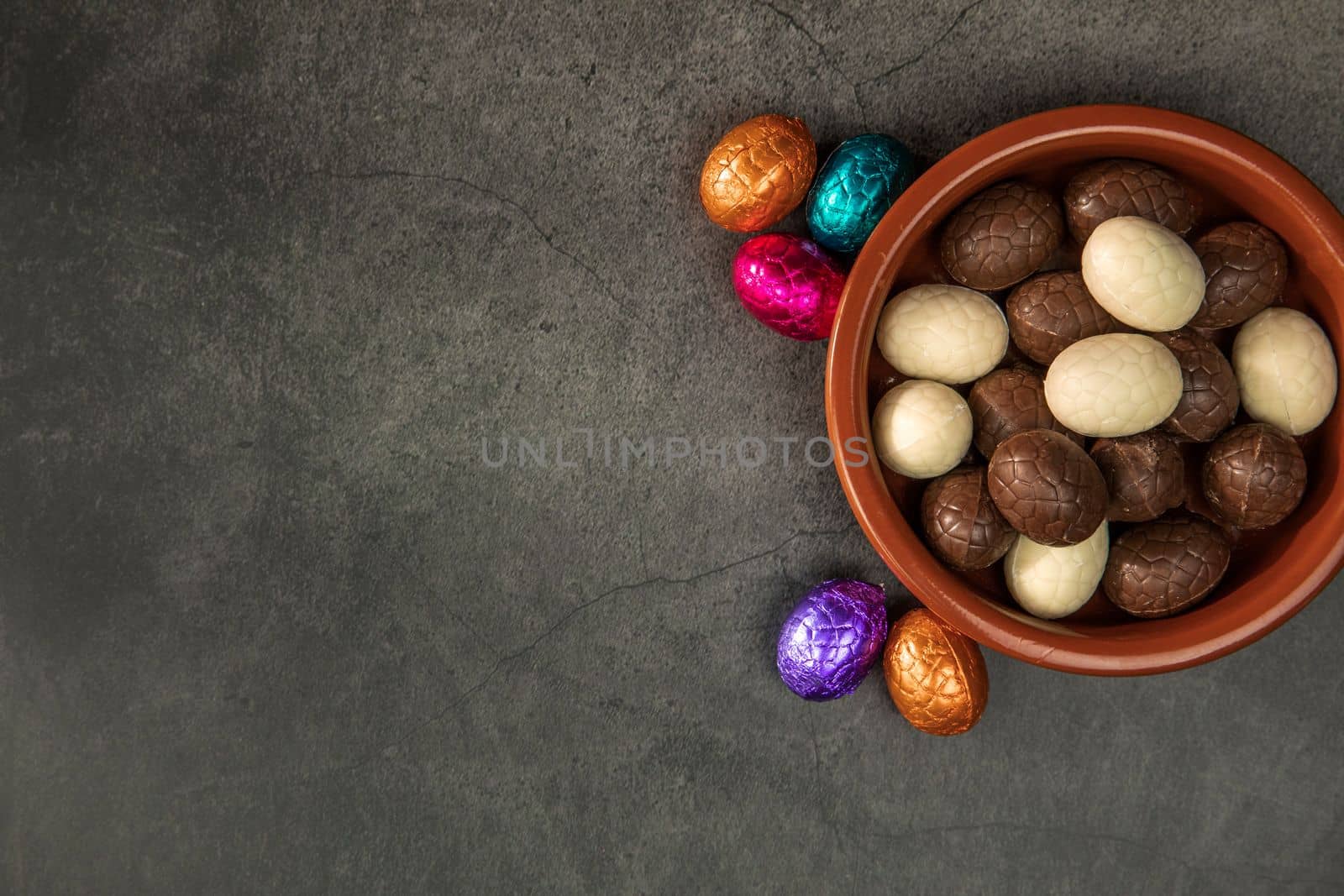 Sweet chocolate easter eggs and candies on grey table, flat lay with copy space, Happy Easter concept on concrete background texture candy concept