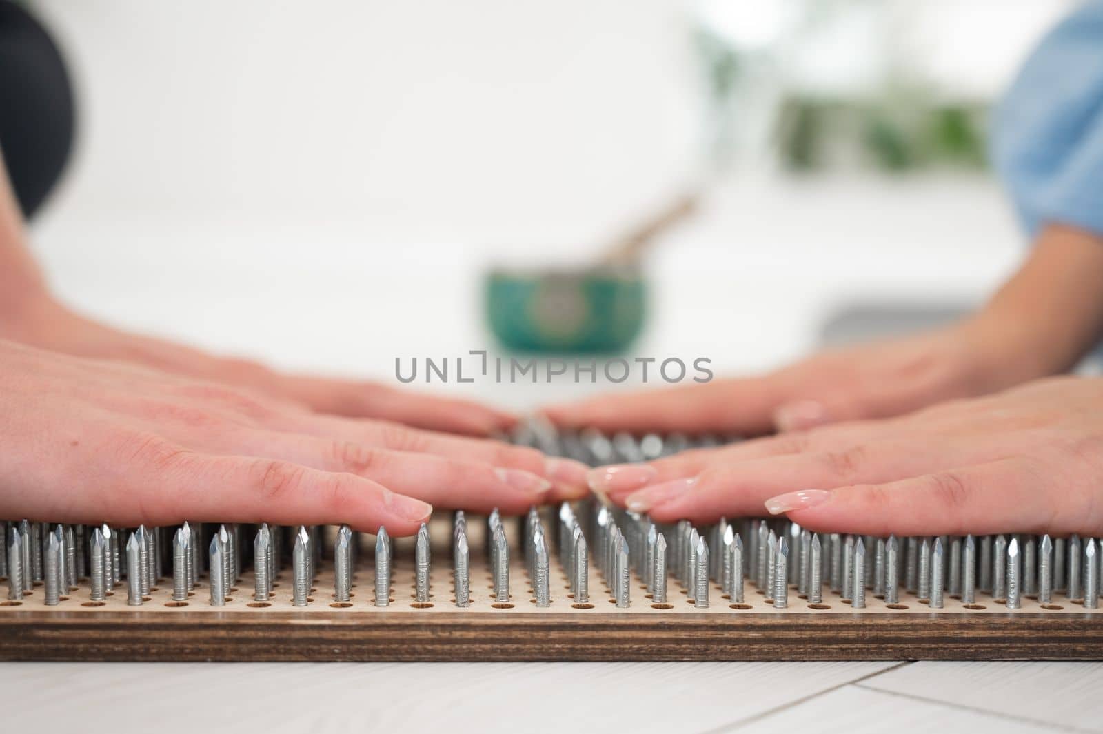 Close-up of two women's hands on sadhu boards. Nailing practice